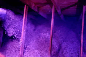 An insulation contractor installing blown-in cellulose insulation in a attic